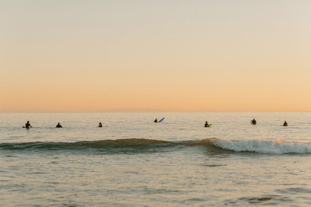 Surfers in the ocean during sunset