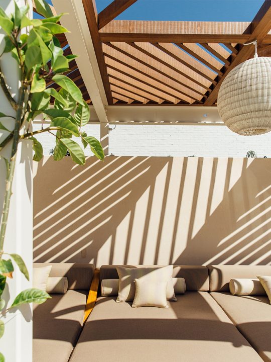 Cabana with lounge chairs and sunshine filtering from above through slatted ceiling