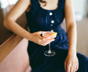 Woman drinking cocktail at Caravan Swim Club