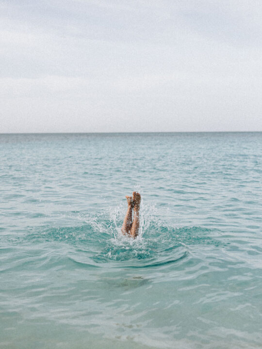 person doing handstand in the ocean