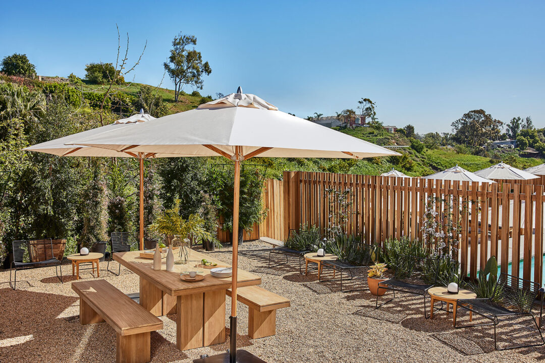 Hotel June Malibu outdoor patio with tables, chairs and umbrellas